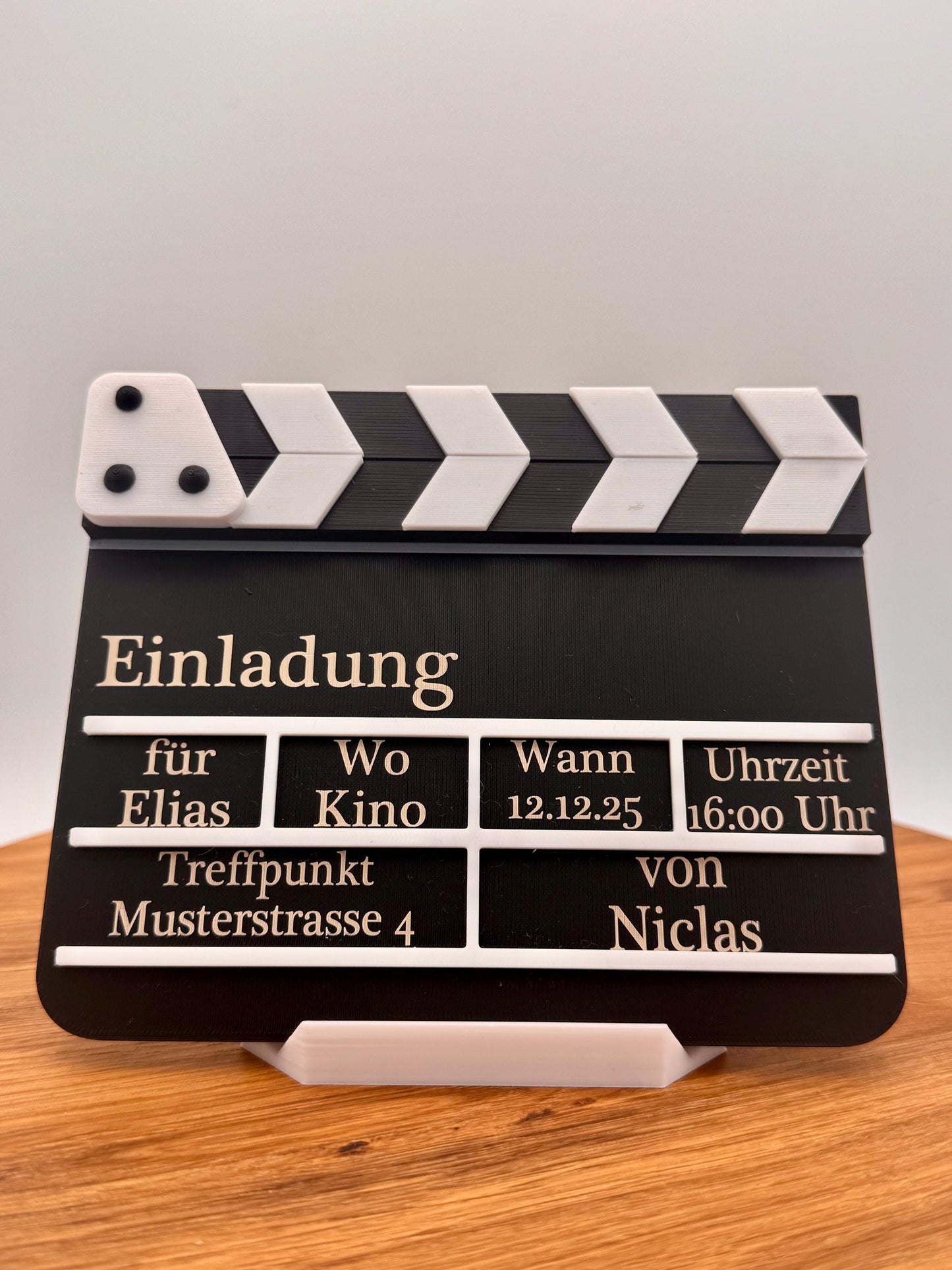 Kino Geburtstagseinladung in Form einer Filmklappe, personalisiert mit Namen, Datum, Uhrzeit und Treffpunkt. Perfekt als kreative Einladungskarte für Kindergeburtstag oder Filmabend.