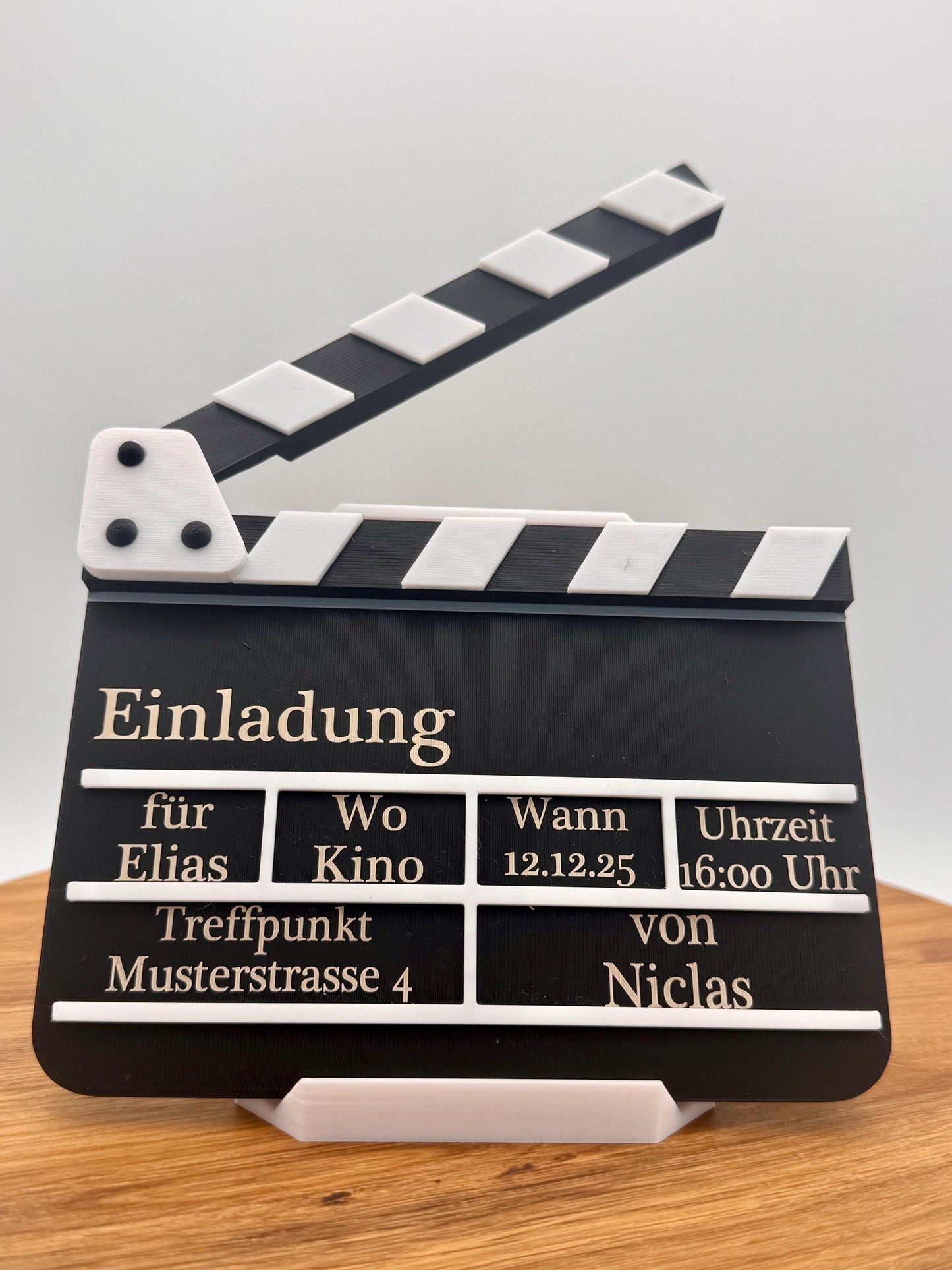 Kino Geburtstagseinladung in Form einer Filmklappe, personalisiert mit Namen, Datum, Uhrzeit und Treffpunkt. Perfekt als kreative Einladungskarte für Kindergeburtstag oder Filmabend.