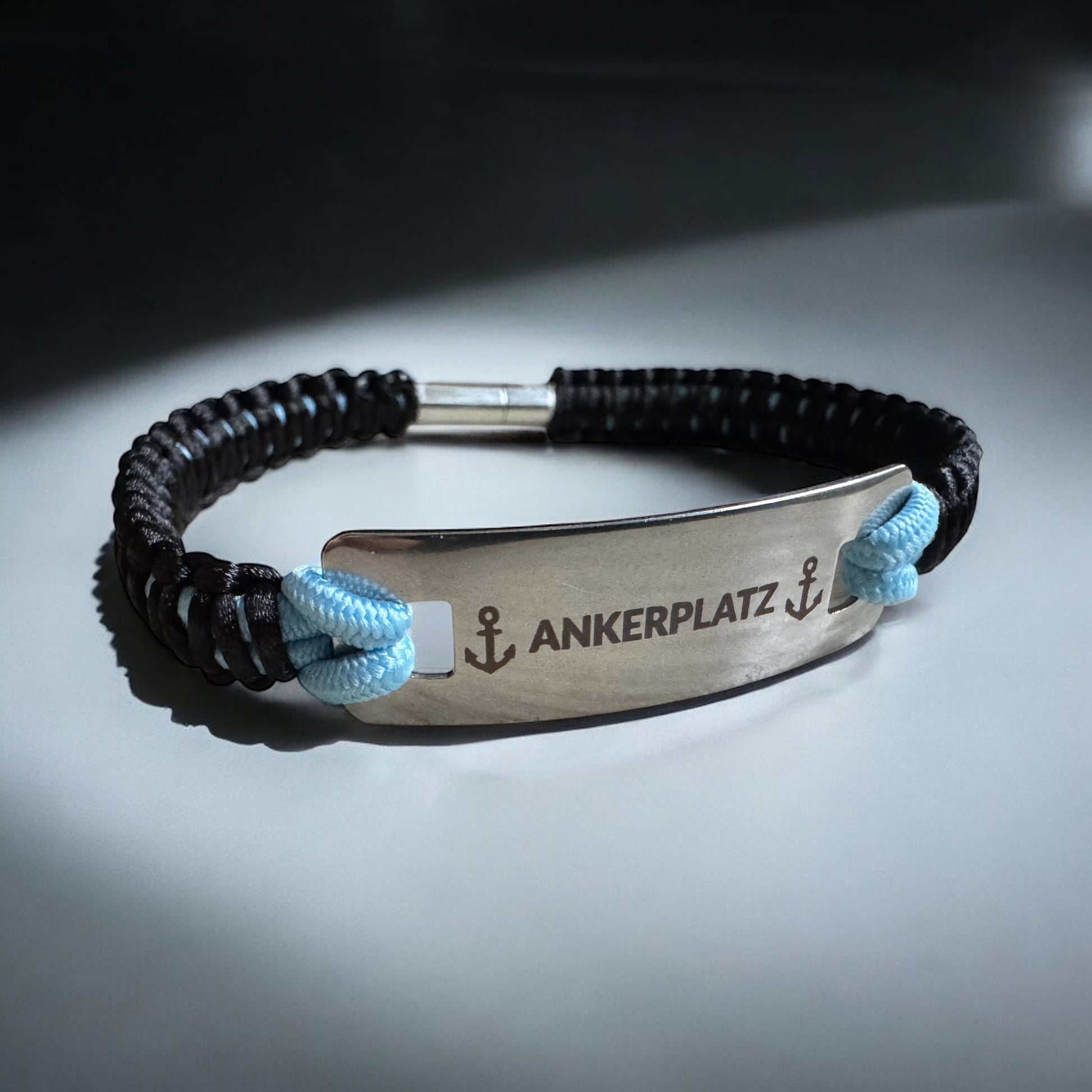 Handgemachtes Paracord-Armband in Schwarz-Blau mit Edelstahlplatte und Gravur „ANKERPLATZ“ sowie Ankersymbolen – maritimes Herrenarmband, personalisierbar