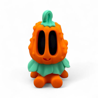 Blob Pumpkin Figur als Halloween-Deko, sitzende orangefarbene Kürbisfigur mit schwarzem Gesicht und grünem Blattkragen, 3D-gedruckt und detailreich gestaltet.