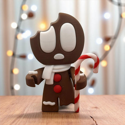 Lebkuchen-Blob Figur mit sichtbarer Bissstelle am Kopf, rote Knöpfe, auf Holztisch – 3D-gedruckte Weihnachtsdeko.