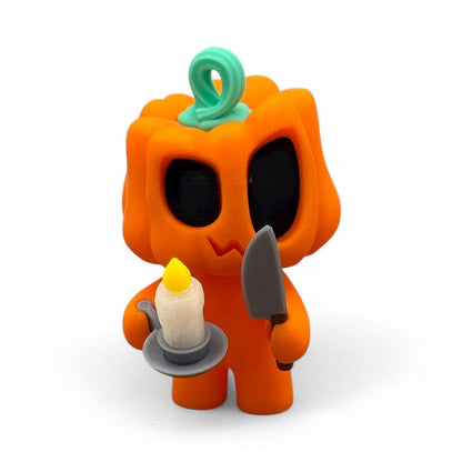 Blob Pumpkin Figur als Halloween-Deko, orangefarbener Kürbis mit schwarzem Gesicht, hält eine Kerze in der einen Hand und ein Messer in der anderen, 3D-gedruckt.