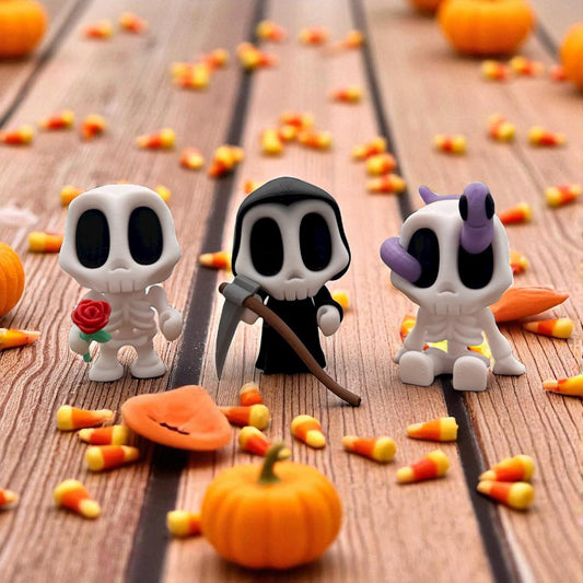 Blob Skeleton Figuren als Halloween-Deko, drei weiße Skelett-Blobs mit unterschiedlichen Accessoires – Rose, Sense und lila Schleife – auf Holztisch mit Kürbissen und Süßigkeiten, 3D-gedruckt.